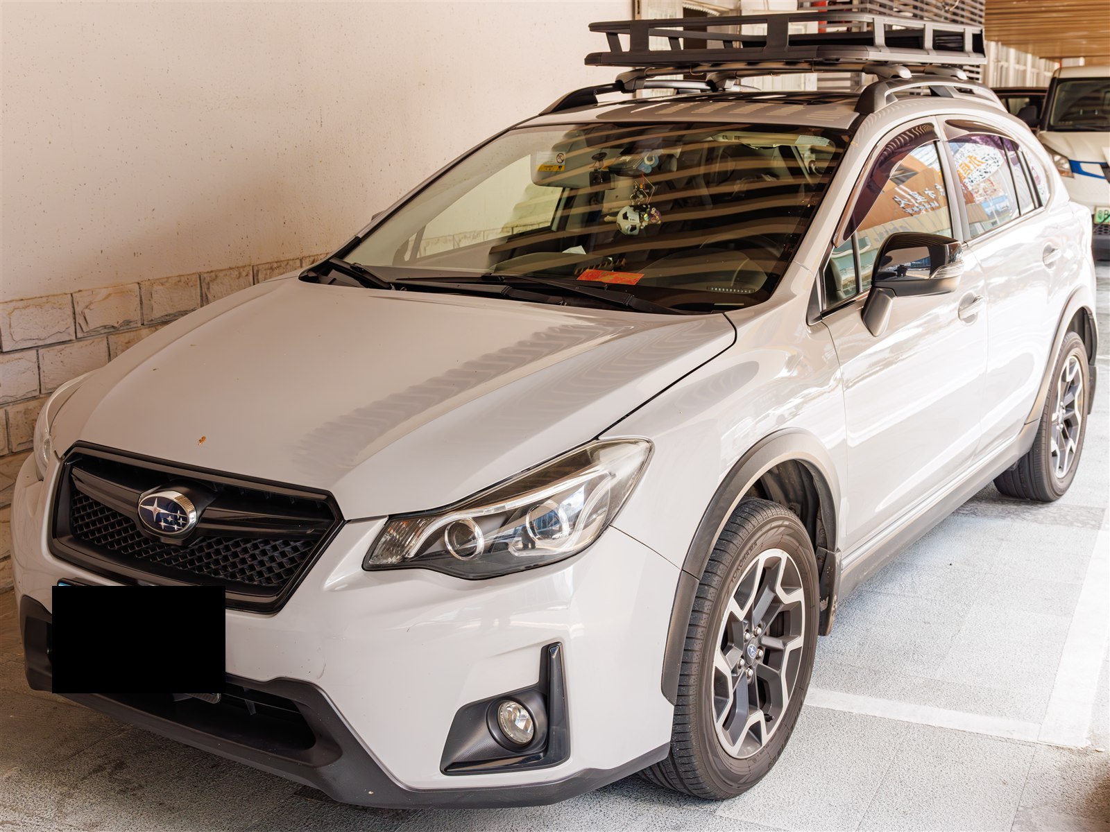 White Subaru Crosstrek with a roof cargo basket, front three-quarter view