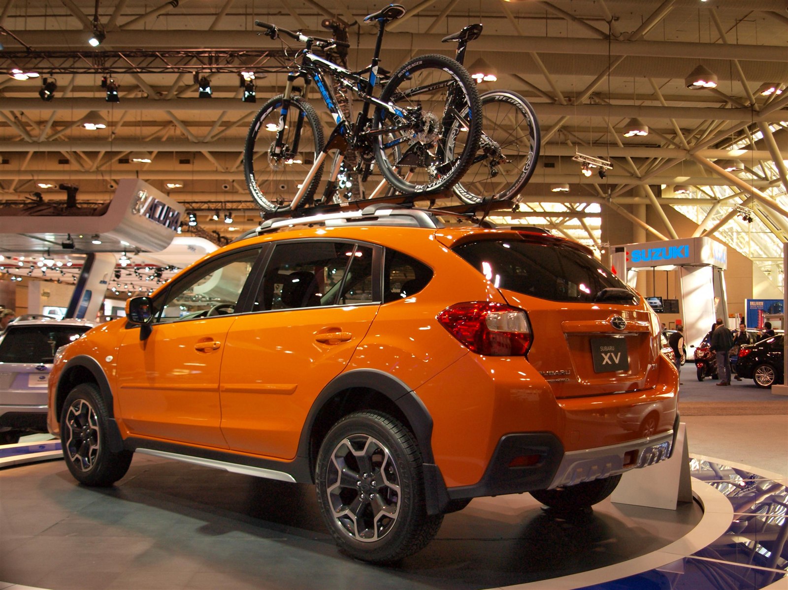 Orange Subaru Crosstrek with two mountain bikes mounted on a roof rack