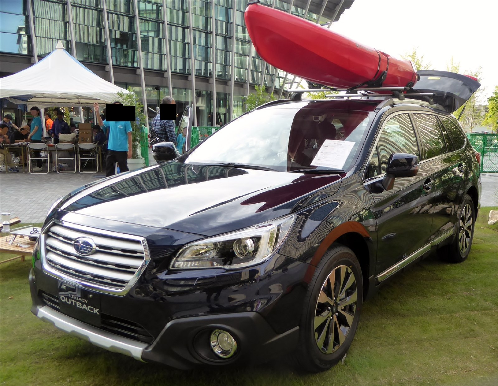 Subaru Outback with a red kayak mounted on the roof rack